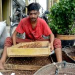 A man sorts black chickpeas at a shop in Saddar Bazaar