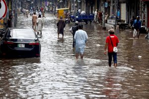 A motorcyclist along with his family members makes his way through heavy rain in the Provincial Capital