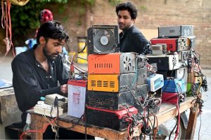 A mechanic busy in repairing battery chargers at his workplace near Royal Road.