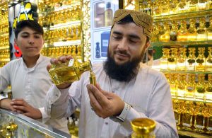 Customers browse and purchase perfumes at a local market.