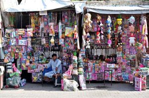 A vendor waiting for customers during selling children's toys near Jinnah Bagh Chowk.