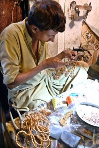 A vendor busy in work at jewelry shop near Shahi Bazaar.