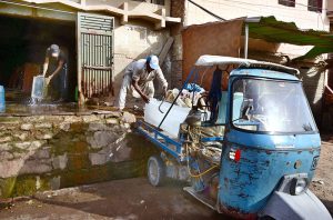 A worker is loading ice blocks onto a tricycle rickshaw at the Ice Factory for delivery to different shops in the city.
