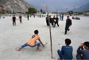 Youngsters play a friendly football match at a local ground in the evening as the majestic mountains and cloudy skies of Gilgit provide a stunning backdrop.