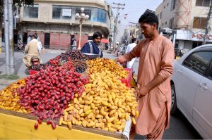 A vendor decorates freshly harvested date crops on his push cart, marking the start of the season and attracting buyers amid rising demand