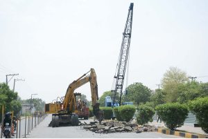 Labourers busy in construction work on Jaranwala Road with the help of heavy machineries during development work in metro project.