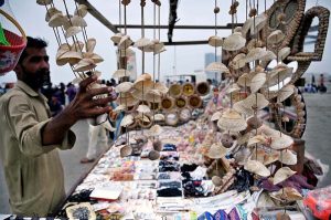 A beachside vendor neatly displays handcrafted seashell souvenirs and decorative items at Seaview, attracting visitors and tourists to sell.