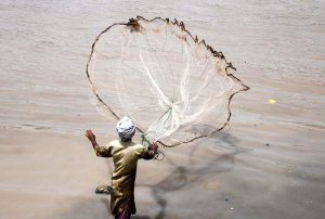 A fisherman casts his net into the Rice Canal in search of a fresh catch.