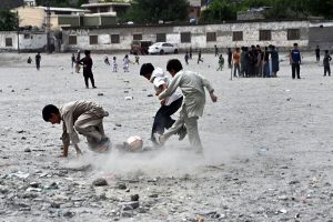 Youngsters play a friendly football match at a local ground in the evening as the majestic mountains and cloudy skies of Gilgit provide a stunning backdrop.
