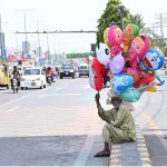 An elderly man is selling balloons on the roadside to earn a living for children, Ferozpur Road