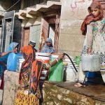 People fill their pots with clean drinking water from a tap at an ice factory in the Makki Shah area