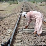 A worker of Pakistan Railways repairs railway track