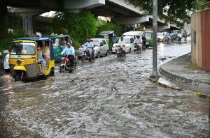 Vehicles passing through stagnant rain water accumulated at Suray Pull Chowk