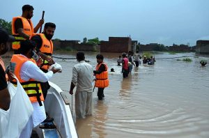Volunteers distribute cooked meals to flood-affected families in Rana Town following heavy monsoon rains that raised the water level of the Ravi River.