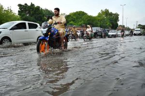 Vehicles passing through stagnant rain water accumulated at Suray Pull Chowk