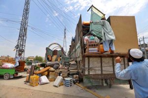 An Afghan national loading household belongings from his residence on a vehicle before departing for Afghanistan under the ongoing repatriation process