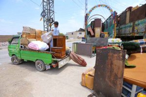 An Afghan national loading household belongings from his residence on a vehicle before departing for Afghanistan under the ongoing repatriation process