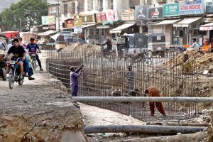 Labourers constructing a sewerage line in Shadman Town as authorities accelerate development work ahead of the expected monsoon rains