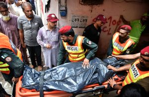 Rescue personnel conduct a search operation amid rubble after the roof of a house collapsed.