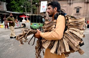 A vendor carrying tree bark (Dandasah) on his shoulder, traditionally used for cleaning teeth near Dehli gate.