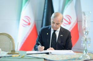 Prime Minister Muhammad Shehbaz Sharif writing his remarks in the condolence book at the Funeral of Late Supreme Leader of Iran, Shaheed Ayatollah Sayyed Ali Khamenei.