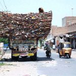A man on the top of an over-loaded truck with empty carton boxes, passing through on Bahawalpur Road that may cause any mishap and needs the attention of concerned authorities