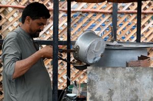 A vendor is busy in making and selling the tea to the customers on the roadside setup in the Provincial Capital