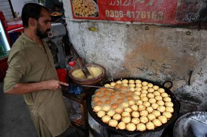 A vendor is busy in making and selling the tea to the customers on the roadside setup in the Provincial Capital