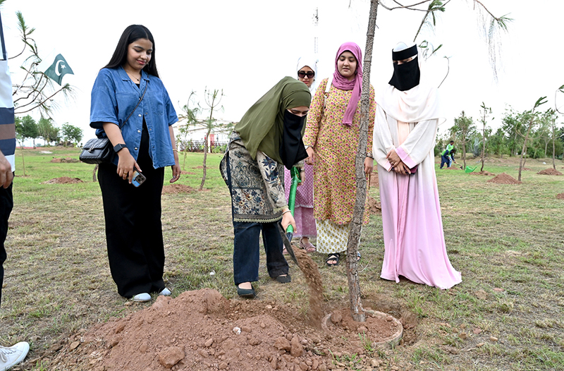 Students plant a sapling during the Tree Plantation Drive organized by the Clean & Green Islamabad Movement at Parade Ground in the federal capital