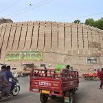 Vehicles pass in front of the historic Pukka Fort at Bacha Khan Chowk during routine traffic activity in the city