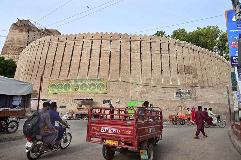 Vehicles pass in front of the historic Pukka Fort at Bacha Khan Chowk during routine traffic activity in the city