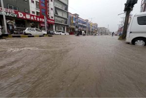 Vehicles wade through a flooded road following heavy monsoon rain in the city.