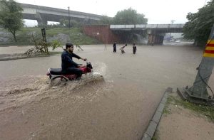Vehicles wade through a flooded road following heavy monsoon rain in the city.