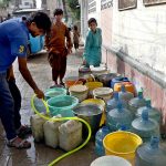 Residents collect water from a borehole for drinking and household use amid a water shortage in the city