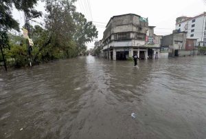 Vehicles wade through a flooded road following heavy monsoon rain in the city.