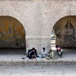 People are spending their spare time playing cards at the railway depot located near the railway station