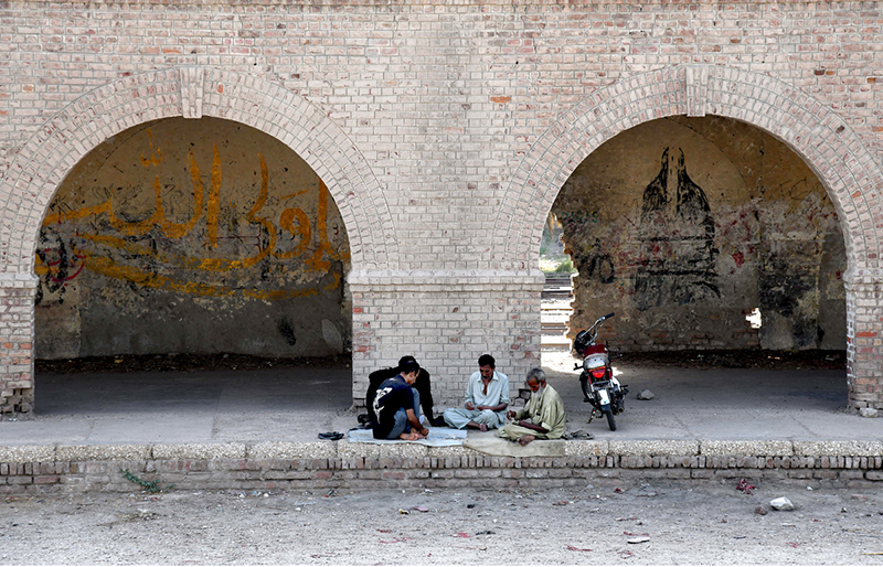 People are spending their spare time playing cards at the railway depot located near the railway station