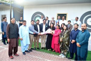 Principal Information Officer Raisa Adil being presented with a shield at the National Press Club by President Abdul Razzaq Sial and Finance Secretary Abid Abbasi on her arrival at the National Press Club.