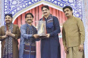 Chief Minister Sindh Syed Murad Ali Shah presents an award to a folk artist during the closing ceremony of the 283rd Urs celebrations of Hazrat Shah Abdul Latif Bhittai at the Bhitshah Auditorium.