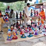 People selecting dolls for their little ones from a roadside vendors’ stall