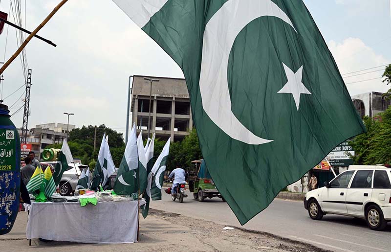 Pakistani flags and Jashn-e-Azadi items displayed at a roadside stall on Tipu Road as part of Independence Day celebrations
