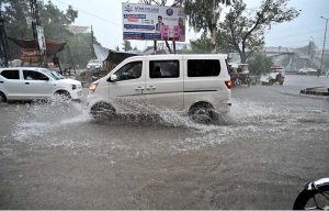 Vehicles passing through rain water accumulated on IJP Road after heavy rainfall in the Federal Capital