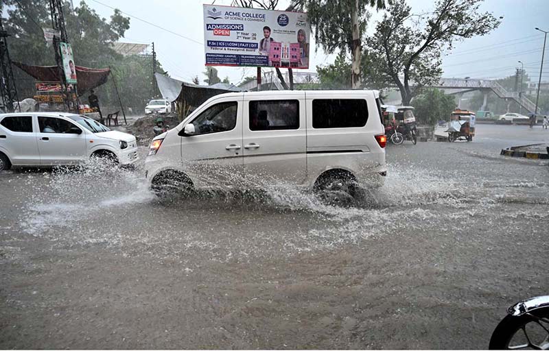 Vehicles passing through rain water accumulated on IJP Road after heavy rainfall in the Federal Capital