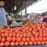 People purchasing fresh vegetables from a stall at Aabpara Weekly Bazaar in the Federal Capital