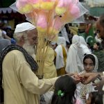 An elderly vendor sells cotton candy at Raja Bazar to earn a livelihood for his family in twin cities