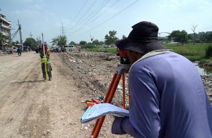 A survey team takes measurements as work continues on the extension and rehabilitation of the Islamabad Expressway service road near Faizabad interchange