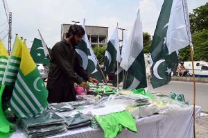 Pakistani flags and Jashn-e-Azadi items displayed at a roadside stall on Tipu Road as part of Independence Day celebrations