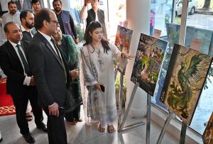 Federal Secretary Information and Broadcasting, Ashfaq Ahmad Khalil, cuts a ribbon to inaugurate a painting exhibition organized by the Directorate of Electronic Media and Publications (DEMP) in connection with Independence Day celebrations, at the Information Services Academy.