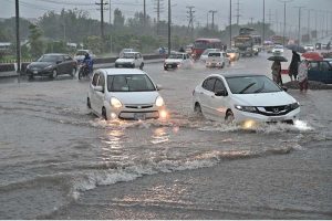 Vehicles passing through rain water accumulated on IJP Road after heavy rainfall in the Federal Capital