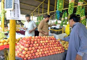 People purchasing fresh vegetables from a stall at Aabpara Weekly Bazaar in the Federal Capital